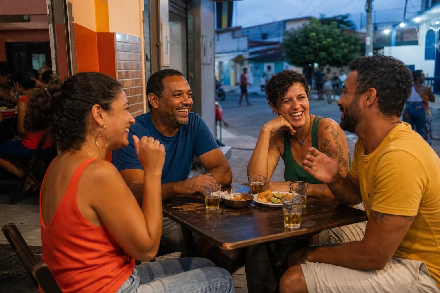Dois casais dividindo uma mesa pequena em um bar de rua